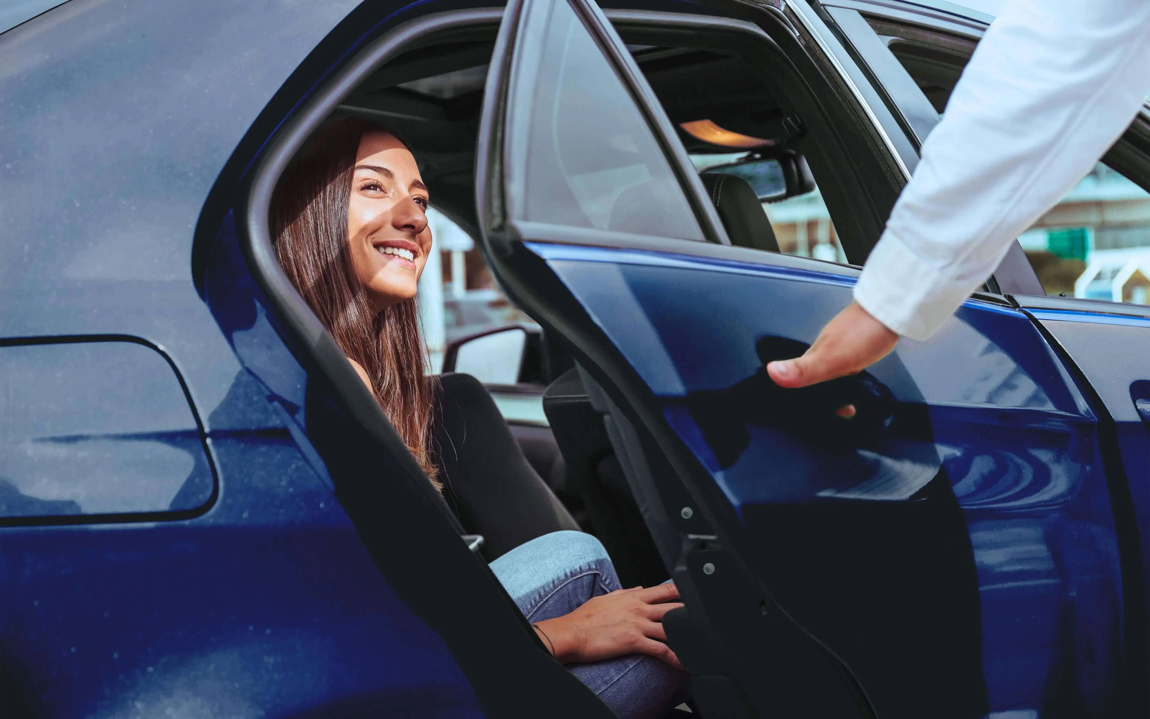 Smiling woman getting into a modern, clean taxi.